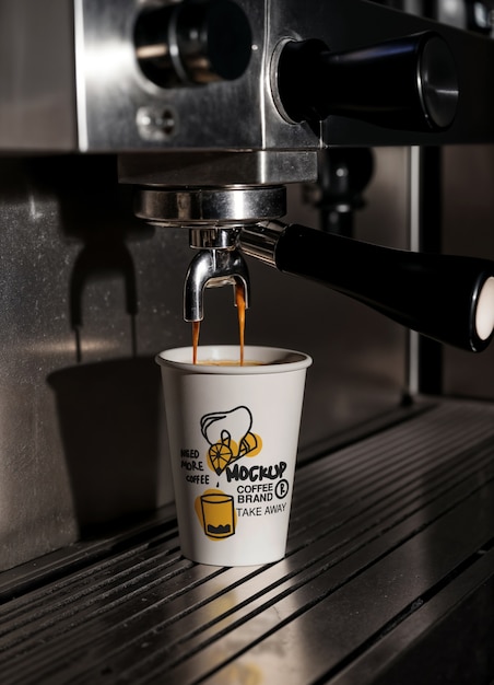 Espresso-Maschine, die Kaffee in eine Papiertasse gießt