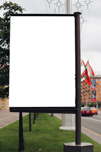 Foto einer großen Plakatwand, die auf der Straße steht, wo viele Leute gehen