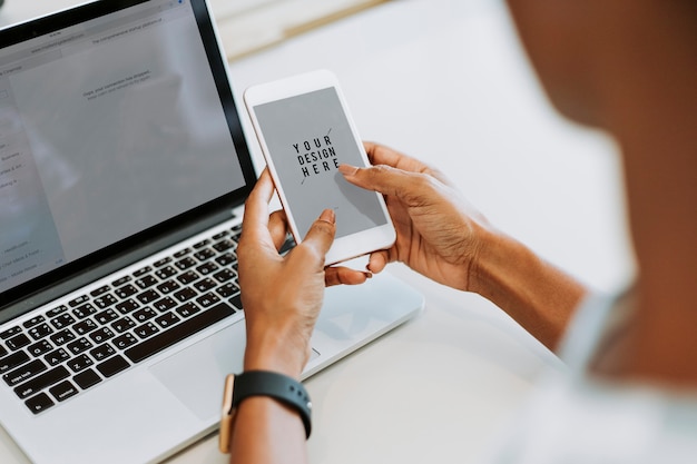 Frau, die Laptop und Smartphone verwendet