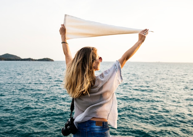 Frau vor dem meer, das flagge hält