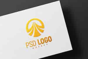 Kostenlose PSD goldenes logo-modell auf weißem papier geprägt