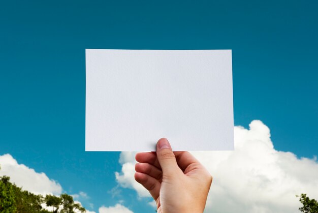 Menschliche Hand, die Wolke perforiertes Papierhandwerk in der Natur hält