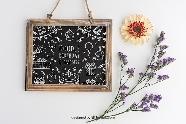 Kostenlose PSD mockup design mit geburtstags schiefer und blumenschmuck