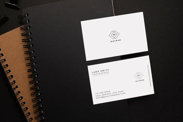 Notizbücher und Visitenkartenmodell mit schwarzem Element auf schwarzem Hintergrund