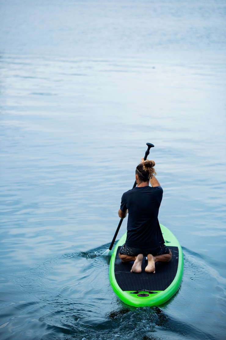 Gratis Foto a man on the lake ride a sup board.