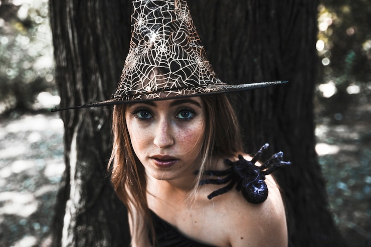 Gratis Foto attractive witch with spider on shoulder in forest datime