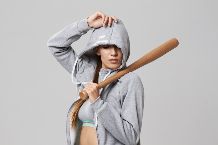 Gratis Foto brutal sportive woman in hood posing holding bit on white.