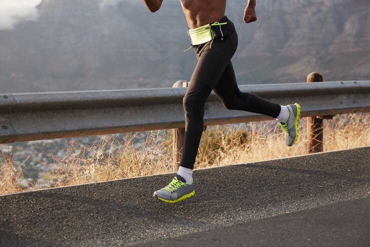 Gratis Foto cropped image of athlete runner runs on road, photographhed in motion, wears comfortable sneakers, takes part in maraphone. focus on foot. sportsman leads healthy lifestyle, covers destination