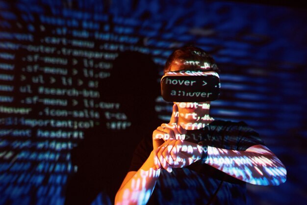Dobbel eksponering av en kaukasisk mann og Virtual reality VR-headset er antagelig en gamer eller en hacker som knekker koden inn i et sikkert nettverk eller en server, med kodelinjer