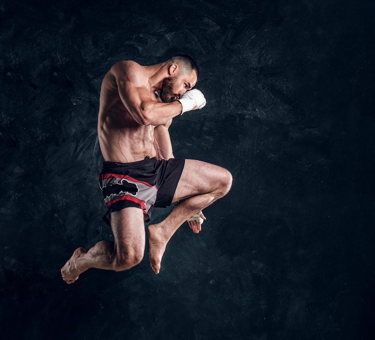 Gratis Foto focused physically fit man is jumping, making illusion of flight before punch an dark studio.