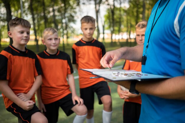 Fotballtrener som underviser elevene sine