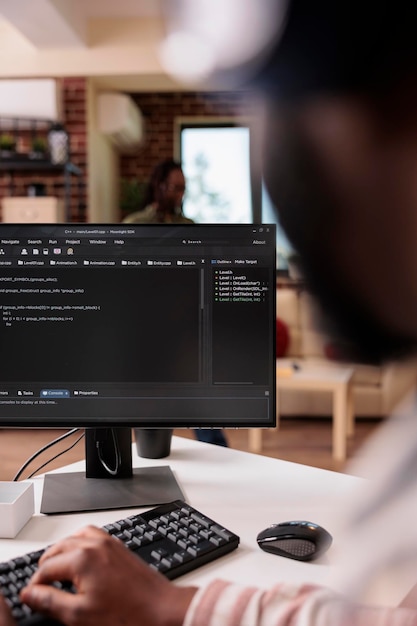 Freelance programmer working remote writing code for software on pc using keyboard debugging algorithm for client. Selective focus on coder computer screen with programming laguage text.