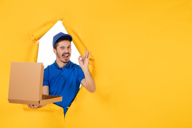front view male courier holding opened pizza box on yellow space