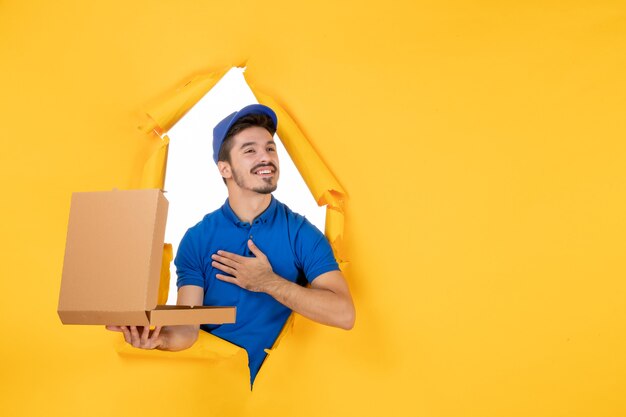 front view male courier holding opened pizza box on yellow space