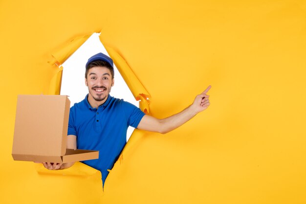 front view male courier opening pizza box on yellow space