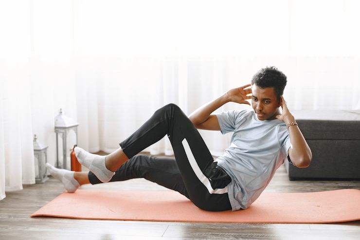Gratis Foto handsome man doing abs exercises at home. concept of healthy life.