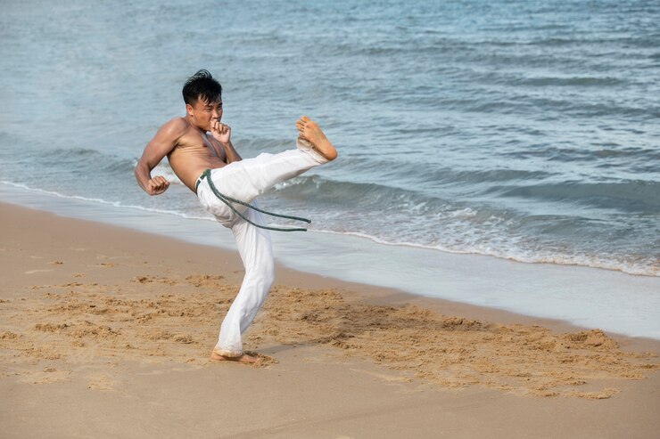 Gratis Foto man by the beach practicing capoeira by himself