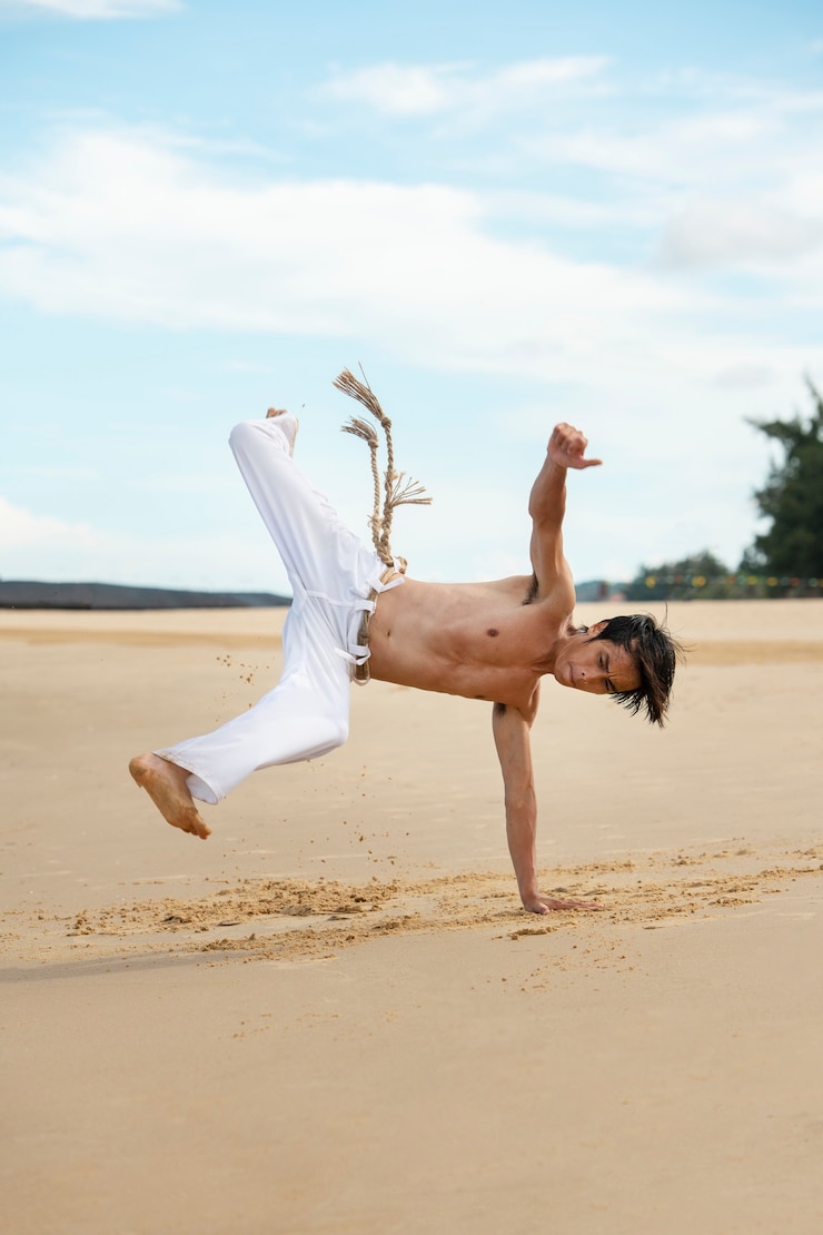 Gratis Foto man by the beach practicing capoeira by himself