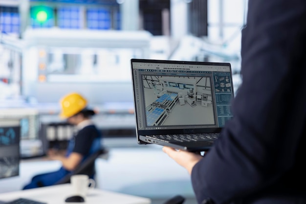 Photovoltaics factory technician improves solar panel configurations with laptop