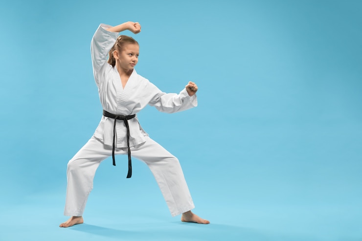 Gratis Foto side view of child standing in karate stance in studio