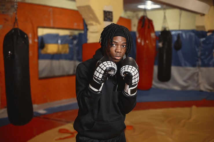 Gratis Foto sporty man boxing. photo of boxer on a ring. african american man training.