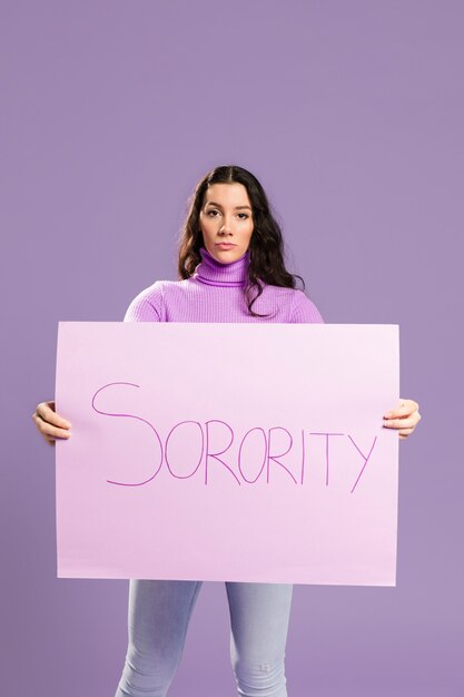 Woman standing and holding sorority cardboard