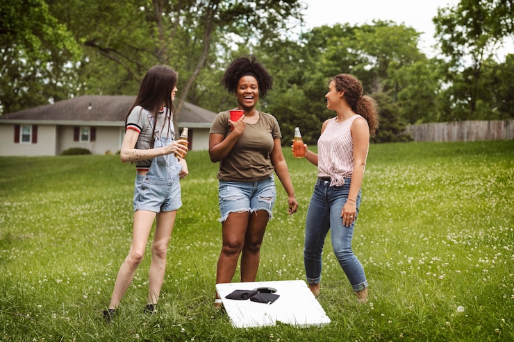 Gratis Foto women chatting during a cornhole game in the park