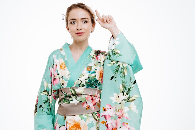 Gratis Foto young geisha woman in traditional japanese kimono looking at front with smile on smart face pointing with index finger up standing over white wall