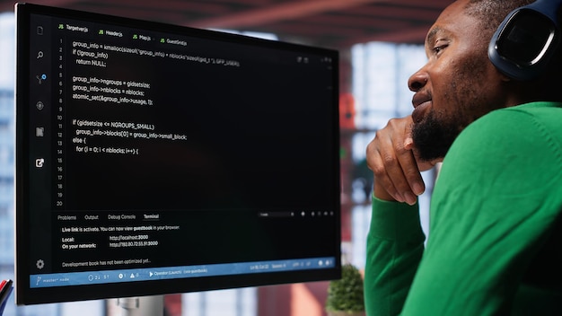Young it engineer typing code on computer and running script programming language african american