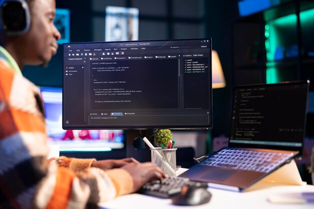 African american computer scientist in home office programming code on pc