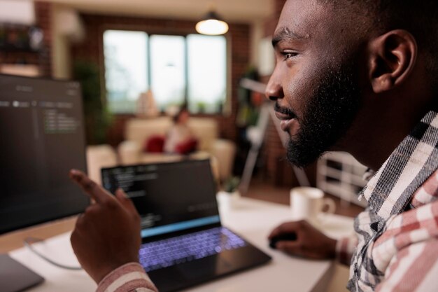 African american it engineer programming binary code interface, using css html script and encryption on computer. Male freelancer coding security server with software developer application.