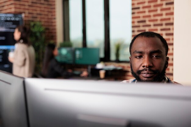 African american programmer developing high security application with multiple layers of scalability. Advanced technology cyber developer creating a node network using binary encryption.