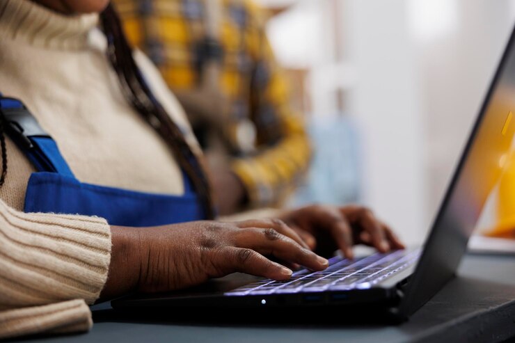 Gratis Foto african american warehouse worker arms writing on laptop and using stock inventory application. storehouse employee checking products listing online and typing on computer keyboard close up
