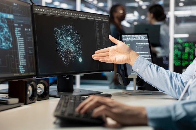 Close up of programmer looking at computer monitor in data center running scripts