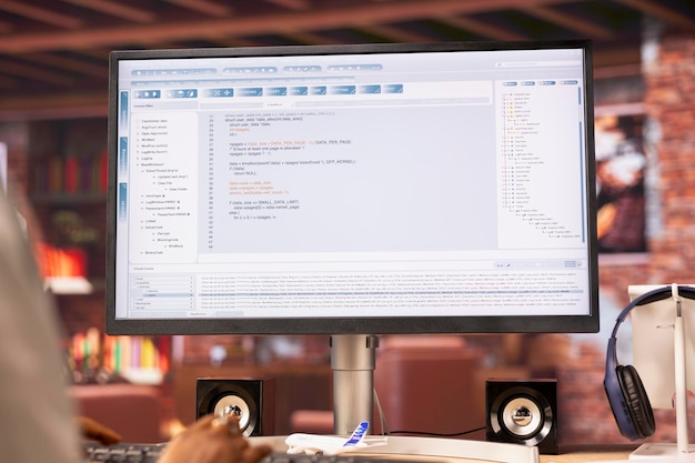 Coder at workstation programming on computer writing lines of code close up