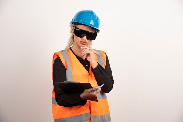 Gratis Foto female engineer in glasses looking at clipboard on white background. high quality photo