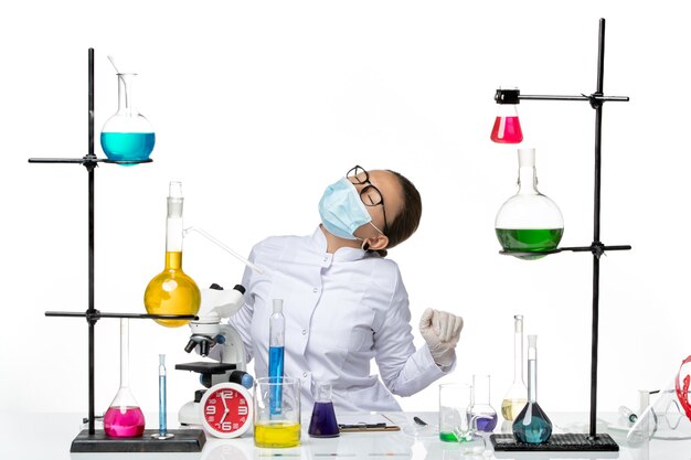 front view female chemist in medical suit with mask in pain on a white background virus chemistry lab covid splash