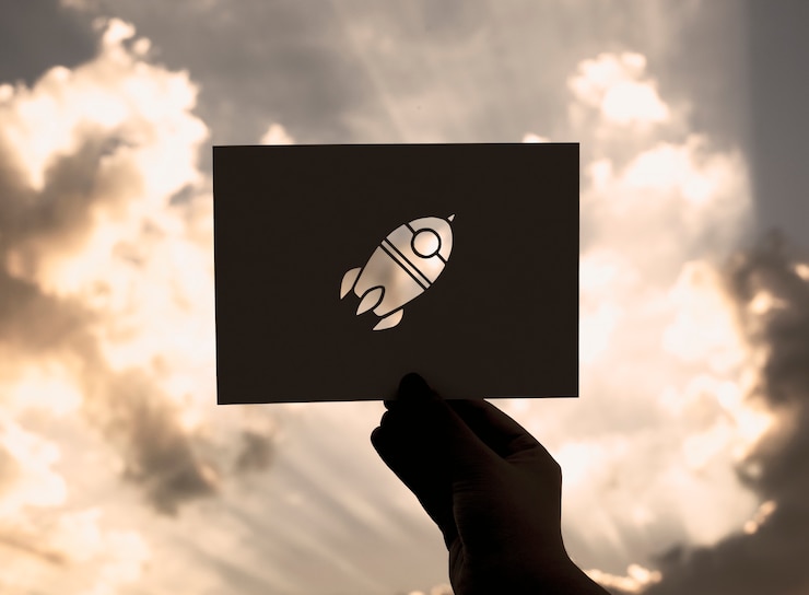 Gratis Bild hand hold space rocket paper carving with sky background