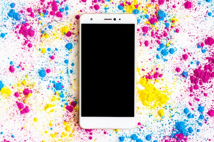 Gratis Bild holi-färgpulver runt smarttelefonen med svart skärm