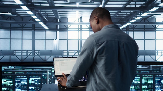 Man coding on data center testing failover scenarios using notebook