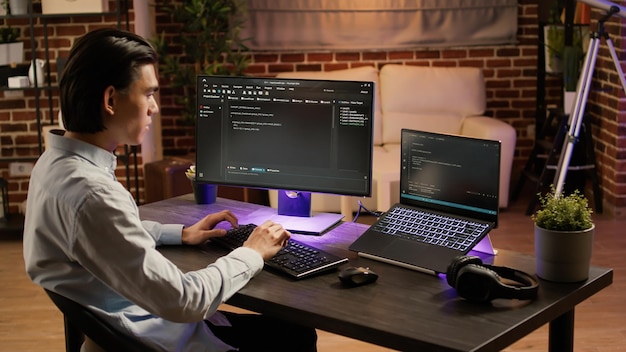 Mandlig systemhacker koder sikkerhedsprogram på pc-software, programmerer firewall-data på krypteringsserver. Bruger computer til at kode applikationsscript på skærmen.