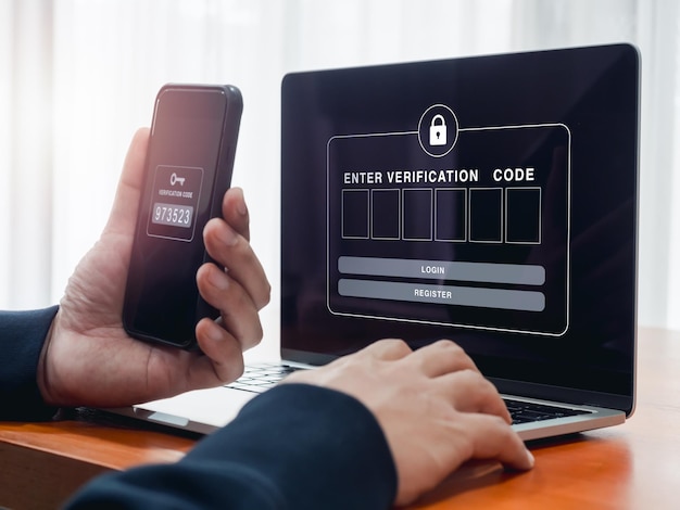 2fa or two factor authentication cyber security concept empty password box for enter verification code show on laptop screen while businessperson man hold smartphone and got passcode key for secure