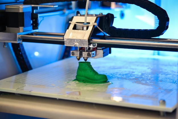 3D printer prints the form of molten plastic green