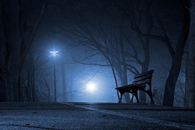 a bench in the dark with a light on it