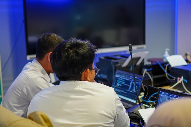 a group of whiteclad office workers gathered in front of their laptops