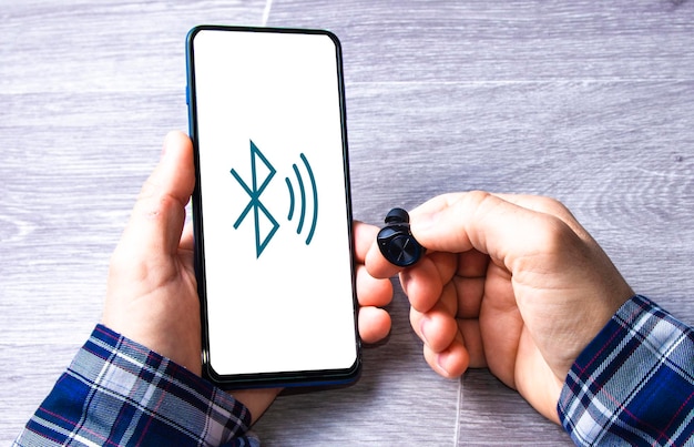 A man connecting wireless headphones to the mobile