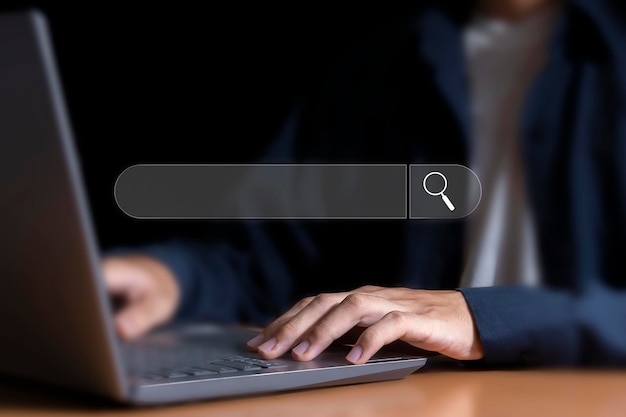A man typing on a laptop with a search bar in the background