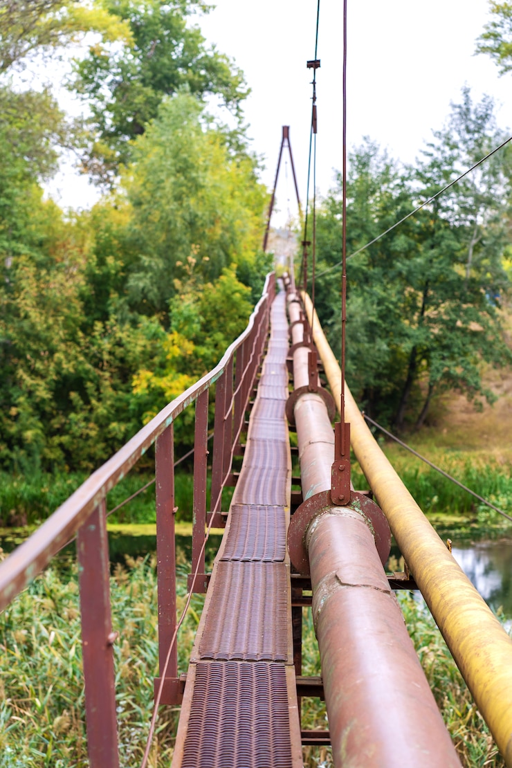 Photo a narrow old rusty river crossing, along with a water and gas pipe. communications in the village.