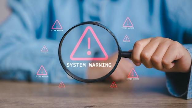A person is holding a magnifying glass over a computer screen that says System W