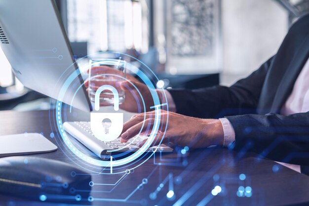 A programmer is typing a code on computer to protect a cyber security from hacker attacks and save clients confidential data Padlock Hologram icons over the typing hands Formal wear